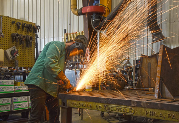 sparks flying as an A to Z Machine employee uses a grinder on a peiceof metal