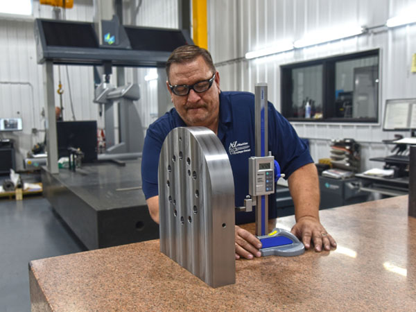 an A to Z Machine employee quality checking a custom made part