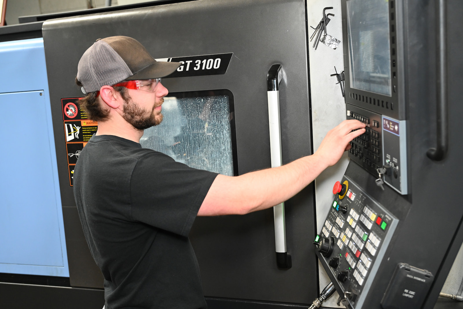 An A to Z Machine employee with glasses and a black shirt is engaged in operating a machine