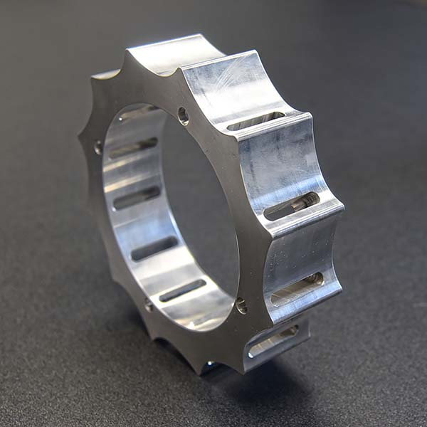 a custom machined gear sitting upright on a table and turned to get a side profile