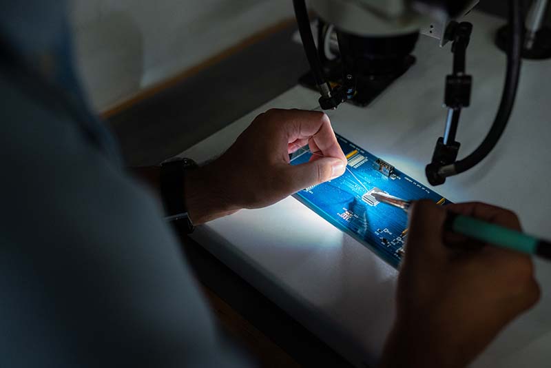 hands working on small electrical component